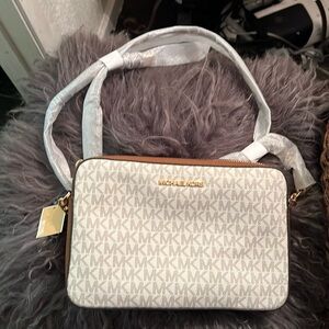 This is a Michael Kors monogram, leather, zip purse, beige